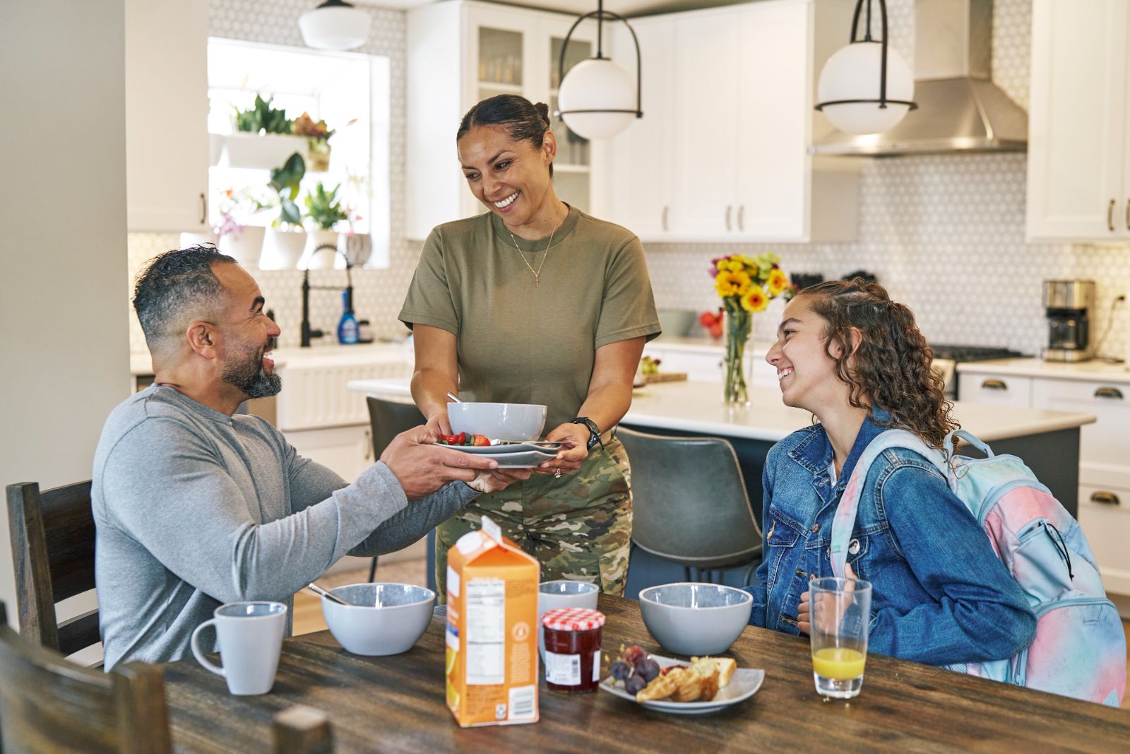 An Army mom serves breakfast to her husband and daughter before school