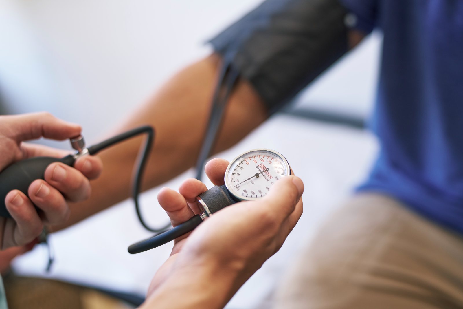 A clinician checks a patient’s blood pressure