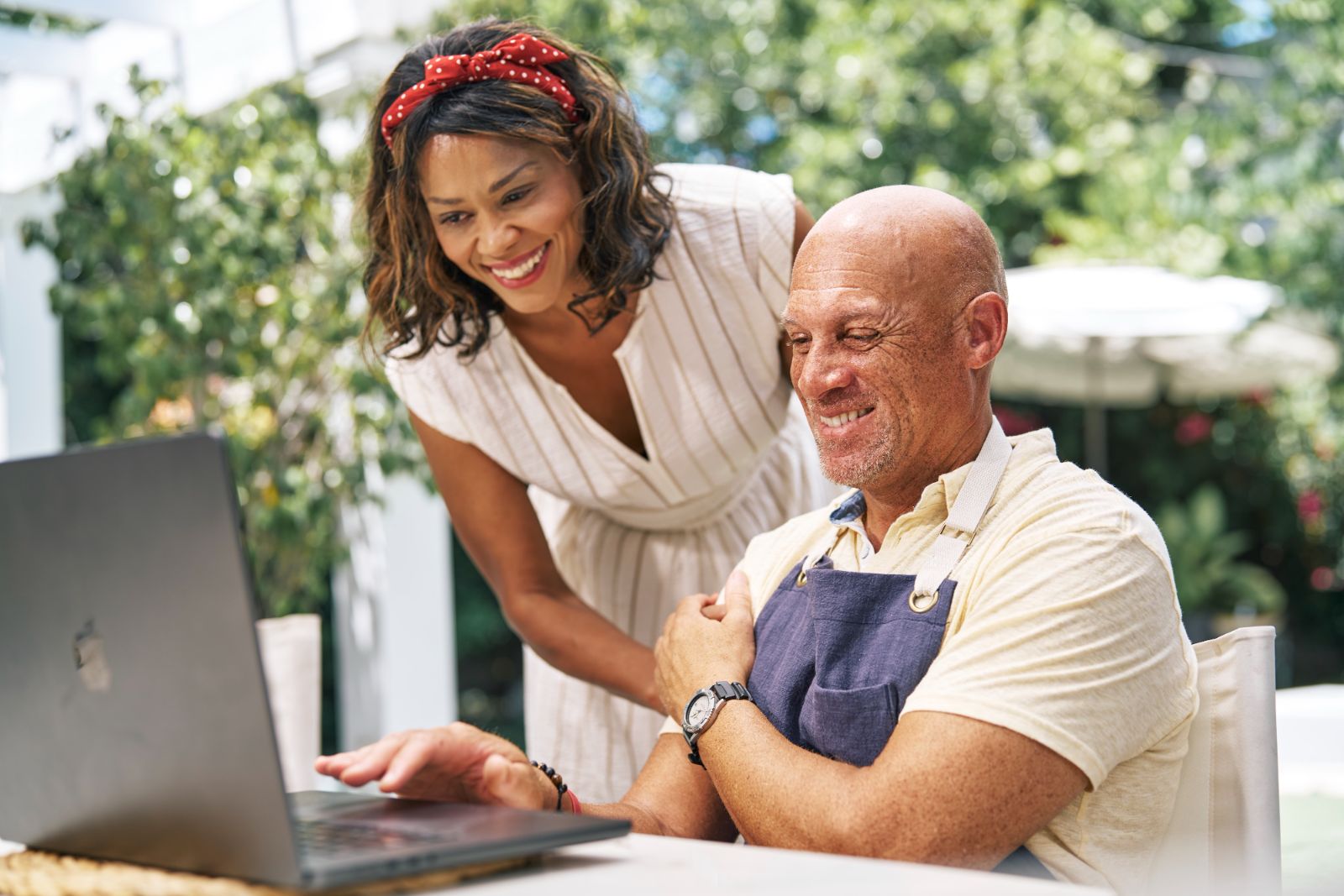 A retired couple reviews their TRICARE Prime Demo options together on a laptop at home in Atlanta