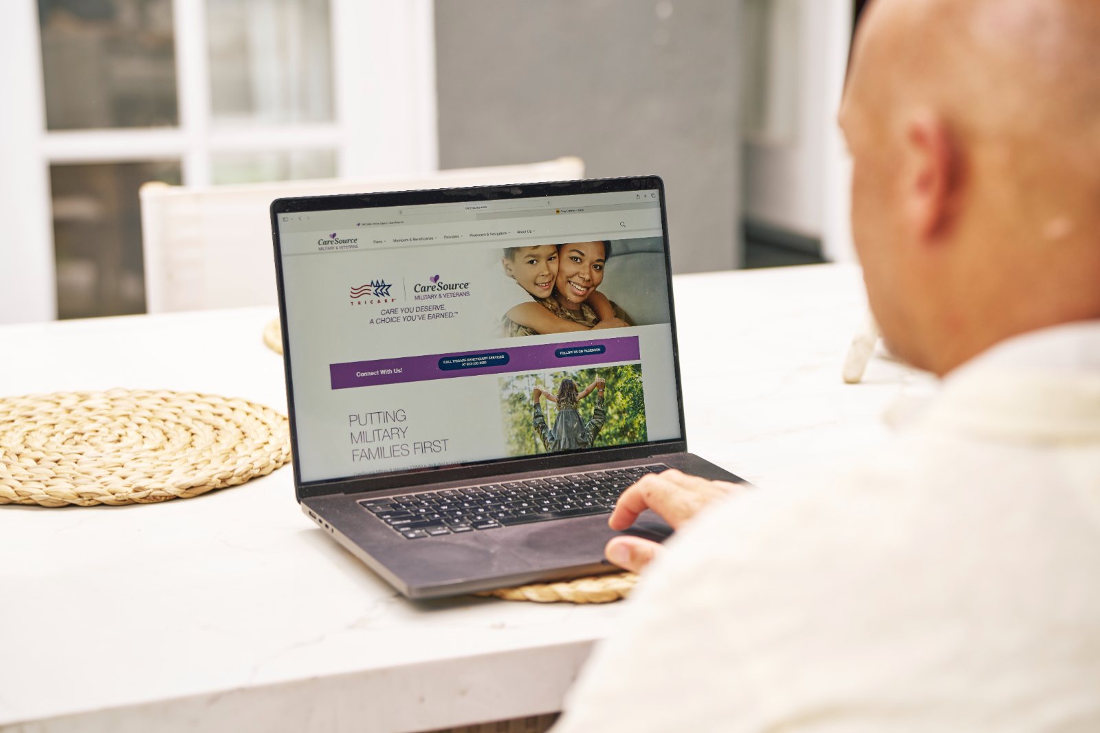 A veteran reads the CareSource Military & Veterans website on his laptop
